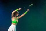 Fototapeta Sport - Badminton player. Woman with racket on green background. Individual sports. Sports recreation.