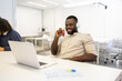 © ADDICTIVE STOCK - Smiling African American man with headphones at work