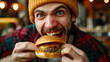 A man enjoying a hamburger fast food meal in the fast food restaurant.