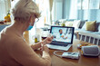 © Davor - Elderly woman in telehealth session with doctor on laptop at home