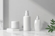 Three white bottles of cosmetics on marble counter