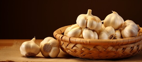 Canvas Print - Fresh garlic bulbs stored in a wicker basket, placed on a wooden table in a rustic setting