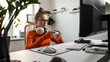 Teenage girl is sitting in a comfortable computer chair, holding a white gamepad in her hands and playing a game on a PC or console. Slow motion shooting.