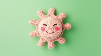 Knitted, cute pink sun with a smile on a green background, top view, with space for text. Greeting card, hobbies, knitting, children's toys.