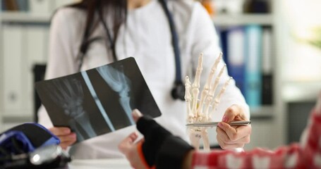 Wall Mural - Doctor and patient are examining an x-ray with hand injury. First aid for injuries concept