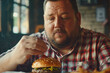 Fat man putting some ketchup on his hamburger
