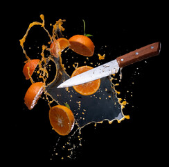 Wall Mural - sliced of orange with juice splash on black background