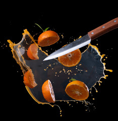 Wall Mural - sliced of orange with juice splash on black background