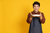 Fototapeta  - Young food waiter Asian man holding empty white plate or dish isolated on yellow background