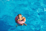 Fototapeta Lawenda - Child in swimming pool. Having fun on vacation at the hotel pool. Colorful vacation concept.