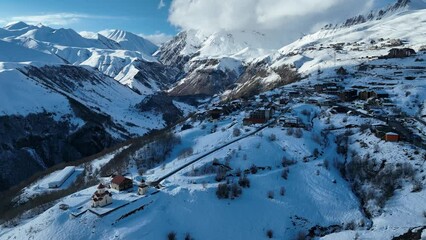 Wall Mural - Aerial drone view of Gudauri ski resort in winter. Caucasus mountains in Georgia. Amaglebis eklesia orthodox church in Gudauri, Georgia. Gudauri Village Panorama with Ski Resort Background.