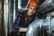 © Anna - Woman plumber working near metal pipes indoor, female professional occupation