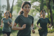 Middle-aged Asian woman in sportswear, short-sleeved shirt, with her friends running exercise, in public nature.
