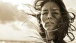 Sepia-toned portrait of a woman with windblown hair at the beach. Serenity and natural beauty concept.