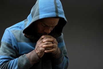 Wall Mural - man praying to god with hands together on grey background with people stock image stock photo	