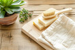 Natural cleaning concept. Handmade soaps, succulent in terracotta, cotton towels and wooden brush on aged wood backdrop, conveying an eco-friendly lifestyle and sustainable homecare