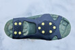 An accessory to improve grip of shoe soles on icy surfaces, studded shoe covers on rubber lining.
