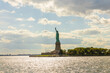 Beautiful view of the Statue of Liberty on Liberty Island in the Hudson River against the backdrop of a blue sky with white clouds. USA.
