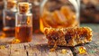 Piece of honeycomb with viscous honey on wooden backdrop. Jars of honey and honeycomb in the blur. Concept of organic produce, apiculture, and healthy sweet.