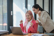 © amnaj - Two asian businesswomen are smiling and celebrating on a laptop