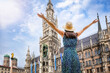 A tourist woman enjoys the beautiful view of the gothic building of the Old town Hall at Marienplatz Square, Munich, Germany 