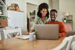 © mavoimages - Smiling multiracial couple taking care of their online banking at home