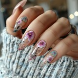 Fototapeta  - Long sharp nails painted with flowers and abstract patterns.
Concept: Nail art, nail design, manicure workshop, femininity and sophistication.
