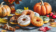 Assorted fall doughnuts with icing and pumpkins.