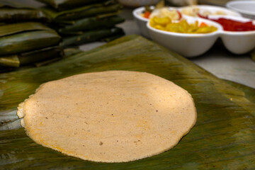 Wall Mural - Corn dough spread on banana leaf, to prepare Hallaca or tamale