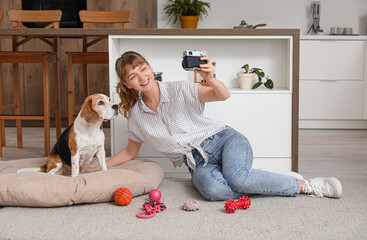 Poster - Young woman taking selfie with cute beagle dog and toys at home