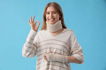 Poster - Injured young woman after accident showing OK on blue background