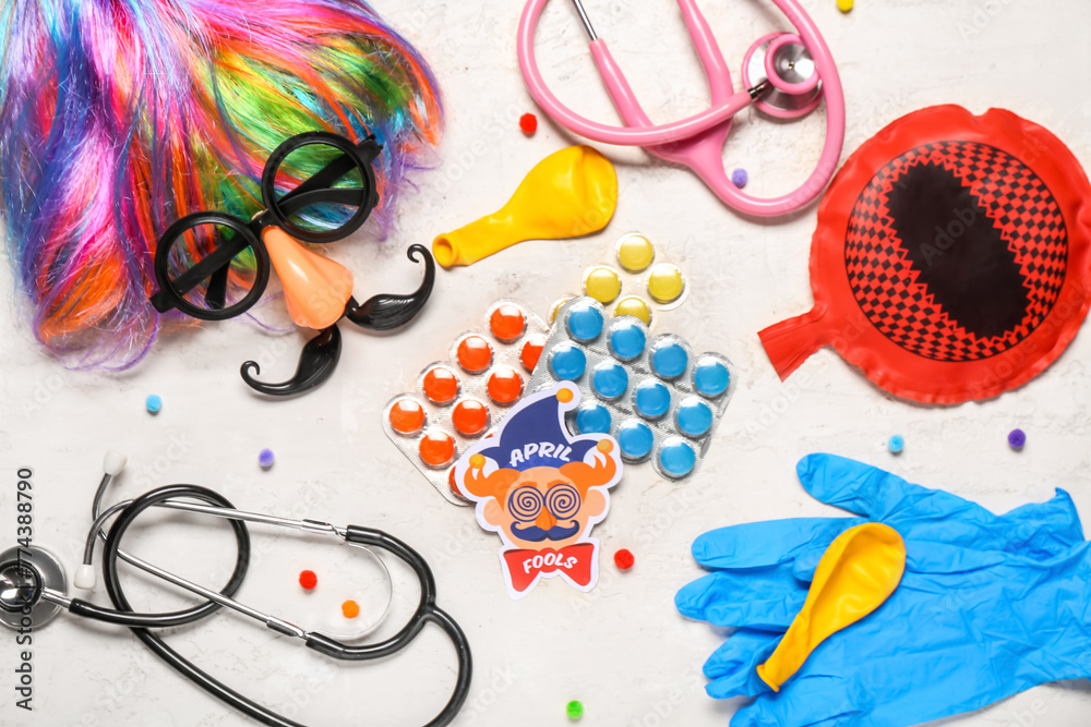 Composition with pills, medical supplies and party decor on light background. April Fool's Day celebration