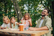 © Zamrznuti tonovi - Playful family is having fun playing with wooden blocks in nature.