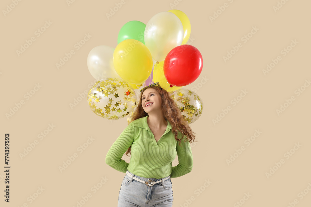 Young woman with balloons on lilac background