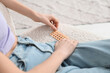 Beautiful young woman with birth control pills on sofa at home