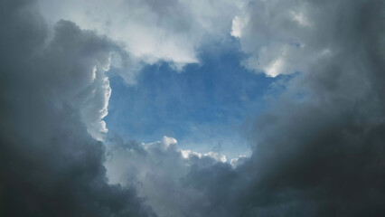 Wall Mural - Storm clouds and hole with blue sky
