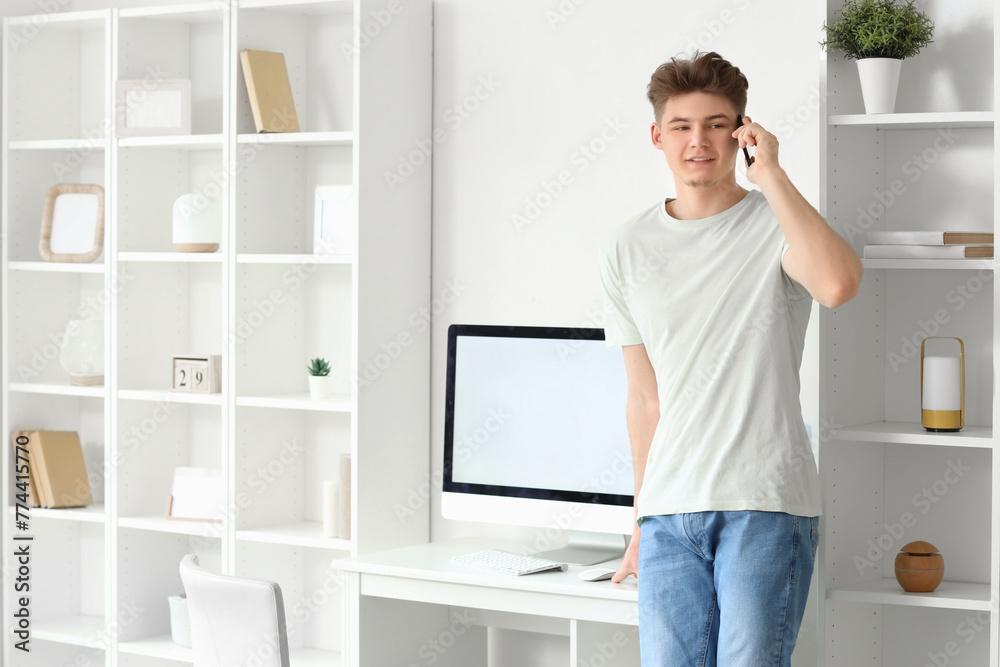 Young man talking by mobile phone at home