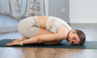Downward facing dog yoga pose - positive young girl doing yoga in fitness studio
