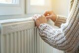 Fototapeta  - No heating concept. cold radiators in the room. woman in a warm jacket in a bright room