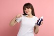 © New Africa - Young woman with mouthwash and toothbrush on pink background