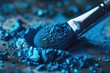 Makeup brush with bright blue eyeshadow on a palette, highlighting texture and color.