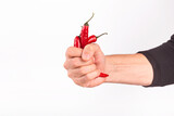 Fototapeta Na ścianę - Close-up view of red chili pepper in the hands of a male cook, selective focus, isolated on white background