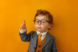 toddler as a boss pointing finger up on bright background