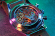 Close up detail of a macro clockwork inside a shiny iron wristwatch with sapphire rear glass bottom.
