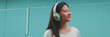 © Andrii Nekrasov - Happy beautiful brunette girl in headphones dressed in casual clothes, listens to music and singing along, Panorama