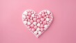 Top view of realistic Christmas candy isolated on pink background in heart shape. Template for greeting card for Christmas and New Year and Valentine's Day