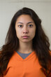 Mugshot of young Native American female prisoner in orange jumpsuit