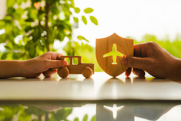 Wall Mural - A child holds a toy car and an adult holds a shield symbol with an airplane, a symbol related to travel and travel insurance.