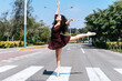 Graceful ballerina dancing on city street crosswalk