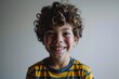 Portrait of a smiling boy with curly hair, studio shot.
